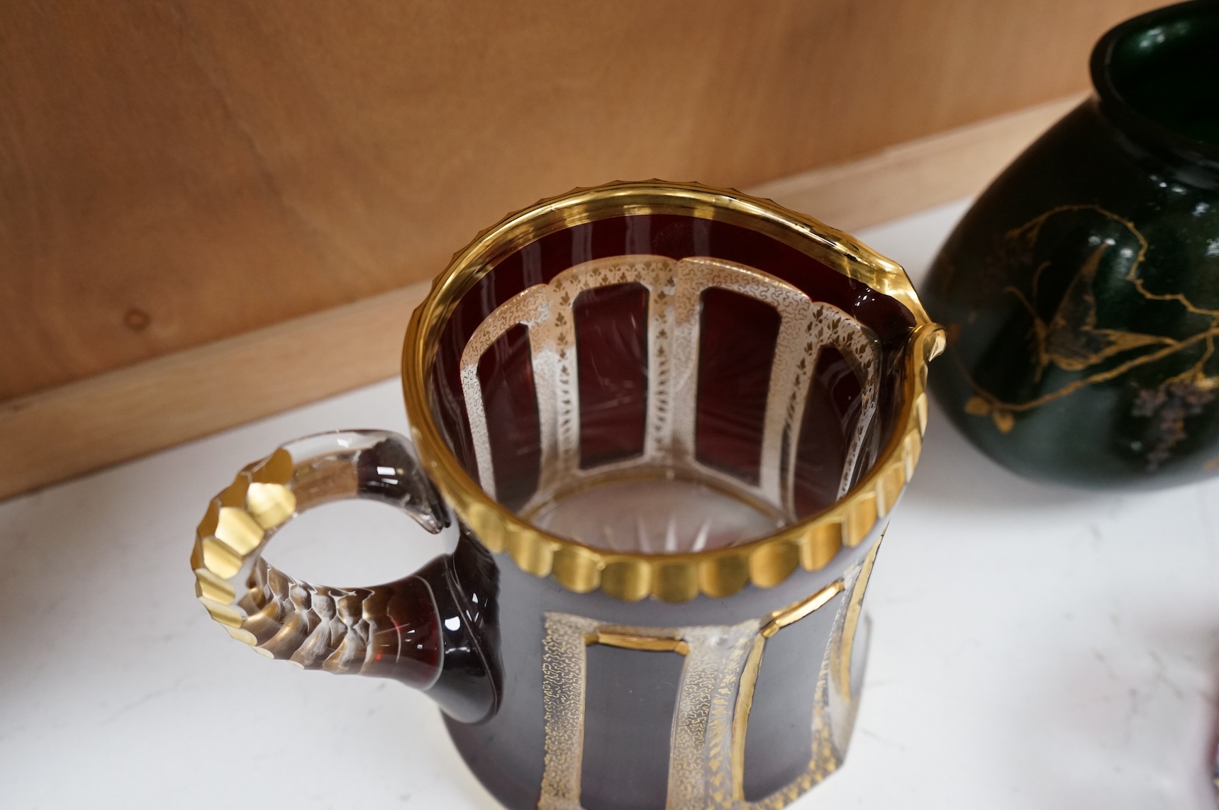 Three pieces of Bohemian and Austrian glassware comprising two jugs and an ashtray, largest 17cm high